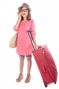 little girl with a red suitcase talking on phone